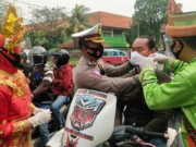 Gunakan Baju Adat di Jalan Raya, Polisi Bagikan 2 Ribu Masker ke Pengendara