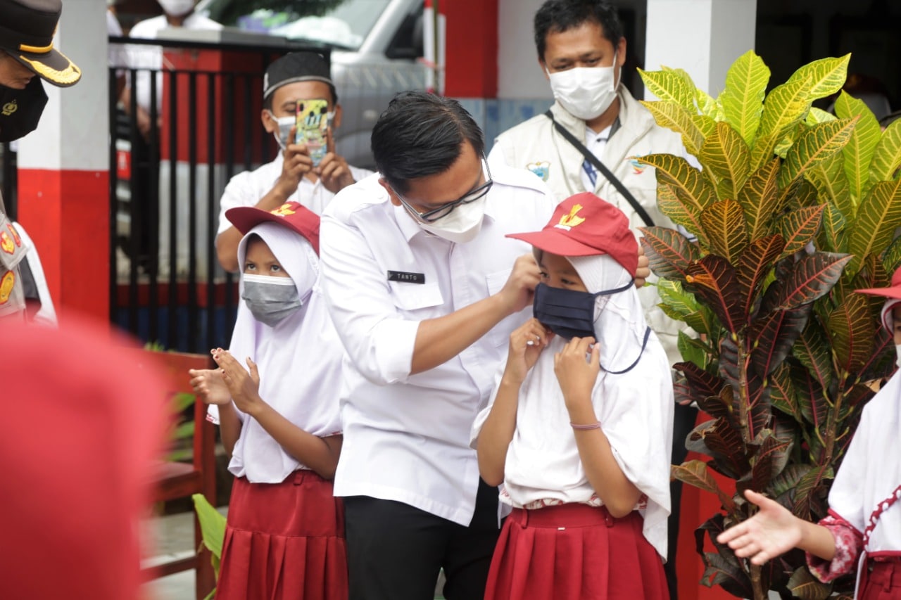Wakil Bupati Pandeglang Tanto Warsono Arban saat memakaikan masker ke anak pelajar SD.