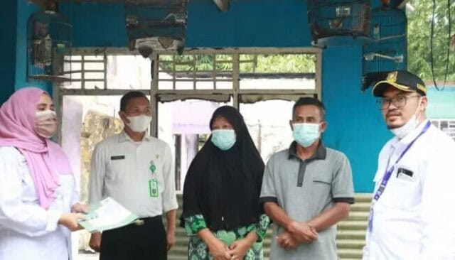 Sekretaris Kecamatan Legok, Kabupaten Tangerang, Farid Ma'arup, saat menyerahkan dokumen Administrasi Penduduk (Adminduk) untuk keluarga Supandi.
