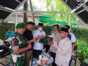 Kepala Desa (Kades) Wanakarta Tumpang Sugian saat menyerahkan baju seragam TNI kepada tim Intel Kodim 0510/Trs di Taman Baso Aci Akang Perum Islamic Kecamatan Kelapa Dua Kabupaten Tangerang, Jum'at (11/03/2022).