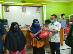 Ketua PWI Kabupaten Tangerang Sangki Wahyudin saat memberikan paket sembako ke warga.