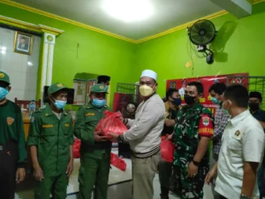 Ketua APDESI Kabupaten Tangerang H. Maskota saat memberikan paket sembako ke warga.