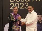 Kepala DPMPD Kabupaten Tangerang, Yayat Rohiman memberikan penghargaan kepada ketua apdesi kabupaten tangerang H. Maskota.dalam acara Desa Award 2023.Foto.(Istimewa)